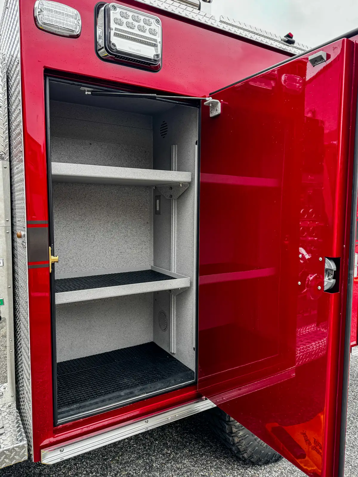 Open side compartment interior with shelf and non-slip compartment floor.